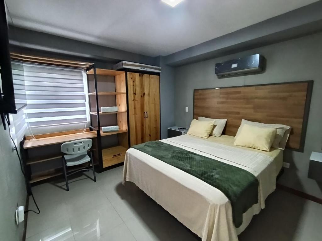 a bedroom with a large bed and a desk at Novedoso Apartamento con Piscina y Wifi gratis in Temblador