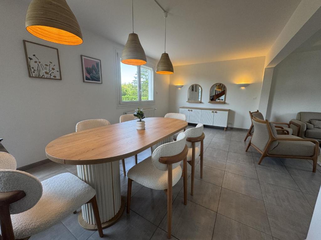 a dining room with a wooden table and chairs at La Porte du Circuit - 8pers - Confort - Rêve au Mans in Bel Air