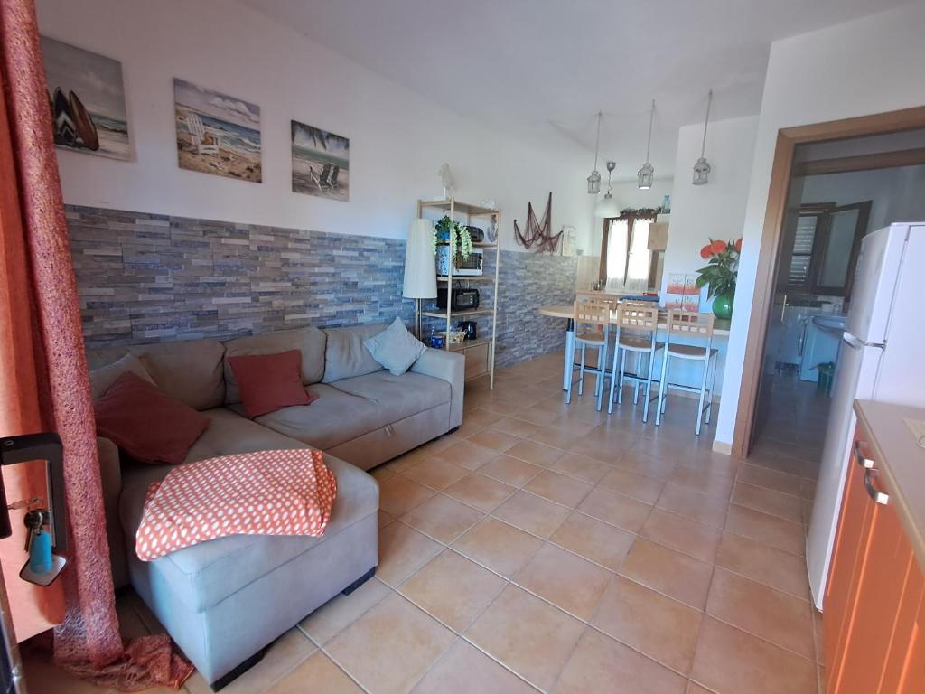 salon z kanapą i kuchnią w obiekcie Appartamento residence Tartaruga 3 w mieście Castelsardo