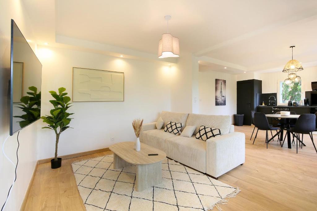 a living room with a white couch and a table at Appartement Toulouse-Moderne-Luxury in Castanet-Tolosan