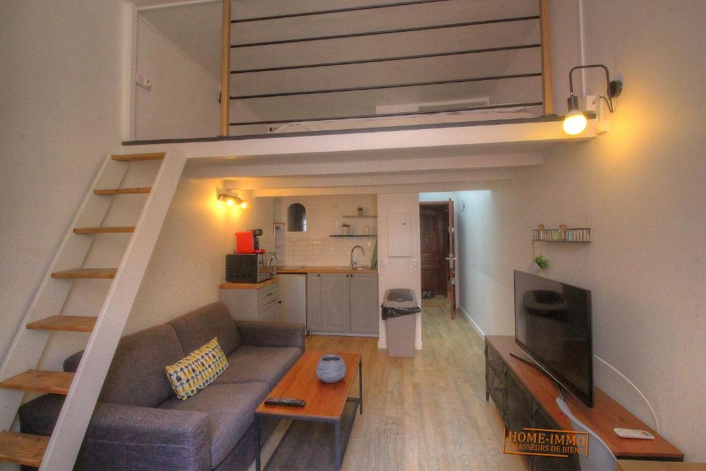 un salon avec un canapé et une mezzanine dans l'établissement Joli studio proche mer, à Vallauris