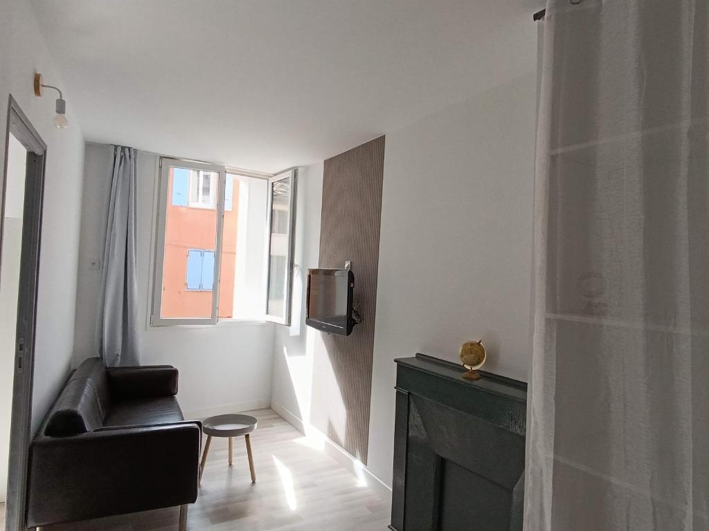 un salon avec une chaise noire et une télévision dans l'établissement Confortable 2 chambres au cœur du Var, à Cabasse