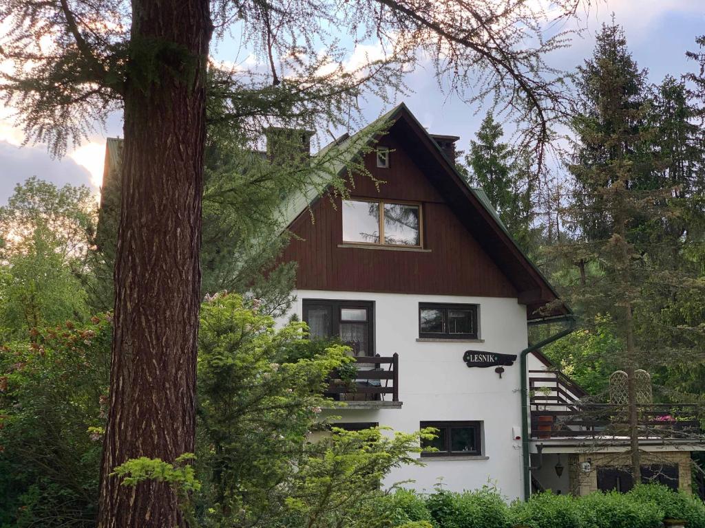 a house with a tree in front of it at Piękny apartament w Pieninach in Krościenko