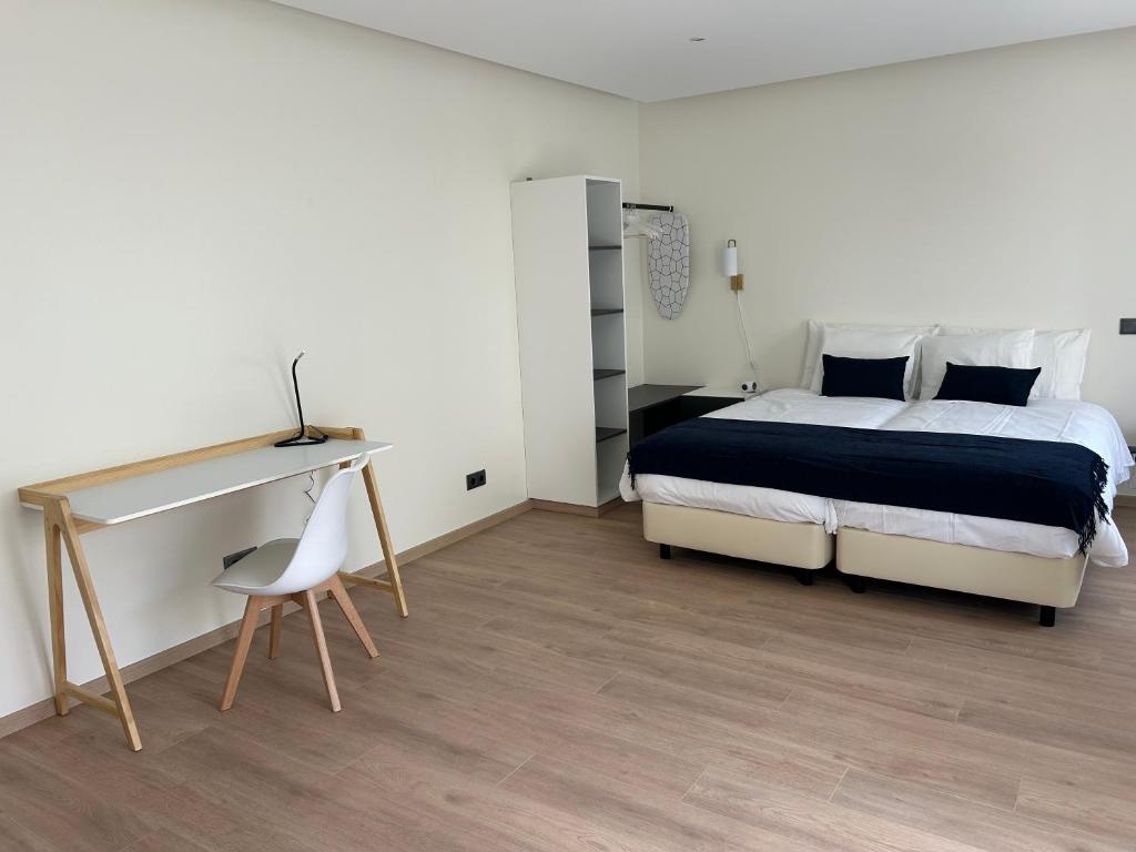 una camera da letto con un letto, una scrivania e una sedia di Casa aOrta Apartments a Faro