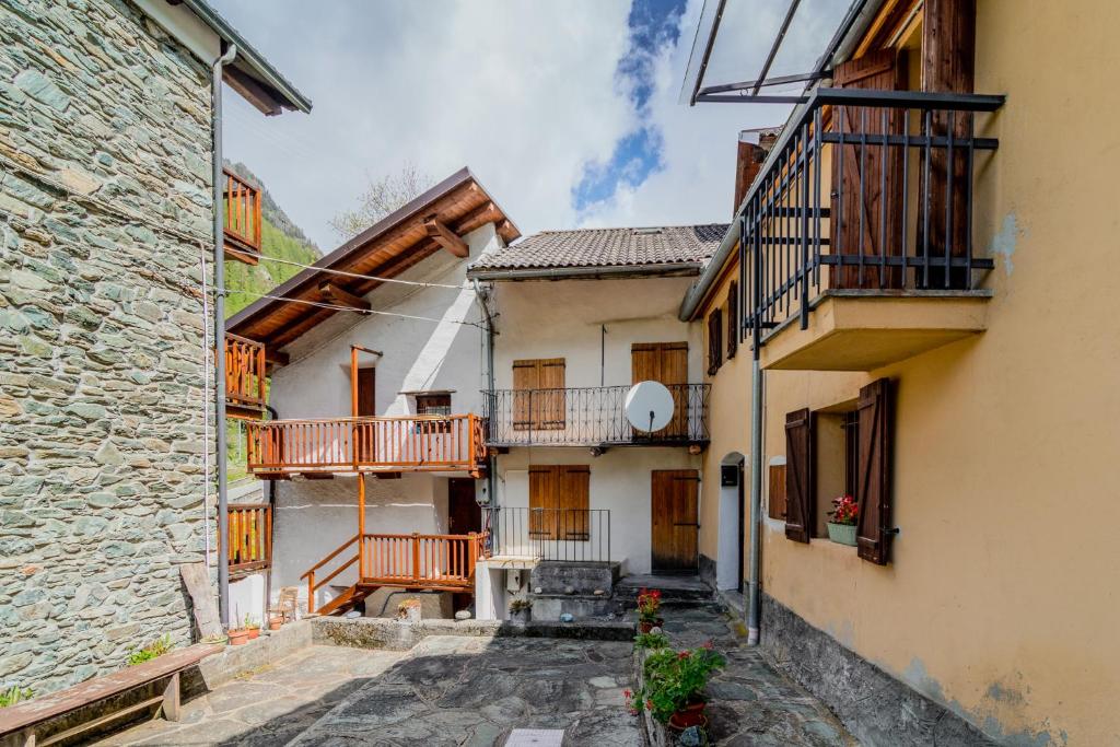 an alley between two buildings with balconies at Soggiornare in Valle Soana in Valprato Soana