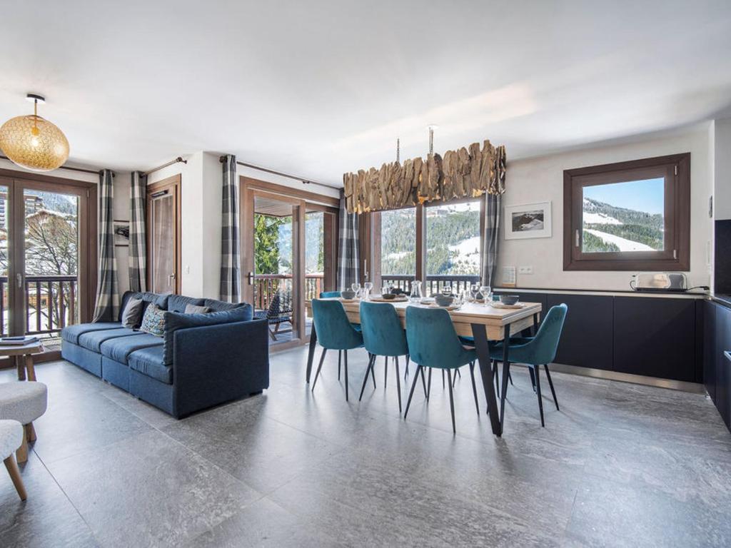 un salon avec une table et un canapé bleu dans l'établissement Appartement 4 adultes-2 enfants, proche pistes, 3 ch, cheminée, parking, Courchevel Moriond - FR-1-563-147, à Courchevel