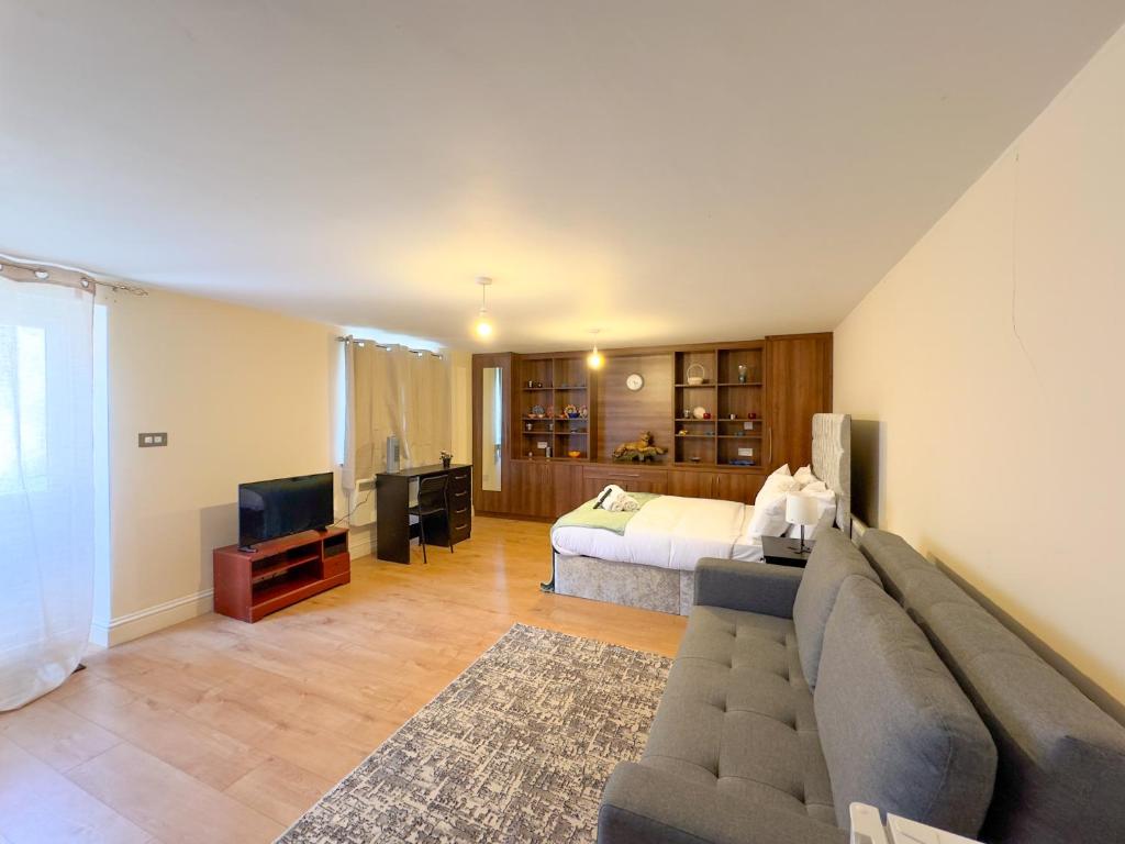 a living room with a couch and a bed at Heathrow Lodge BnB in Harmondsworth