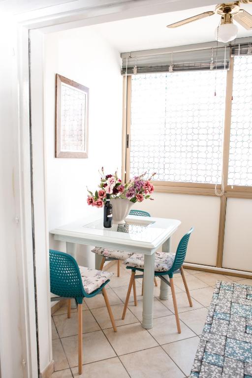 a dining room with a white table and chairs at Appartamento LUX in Scalea