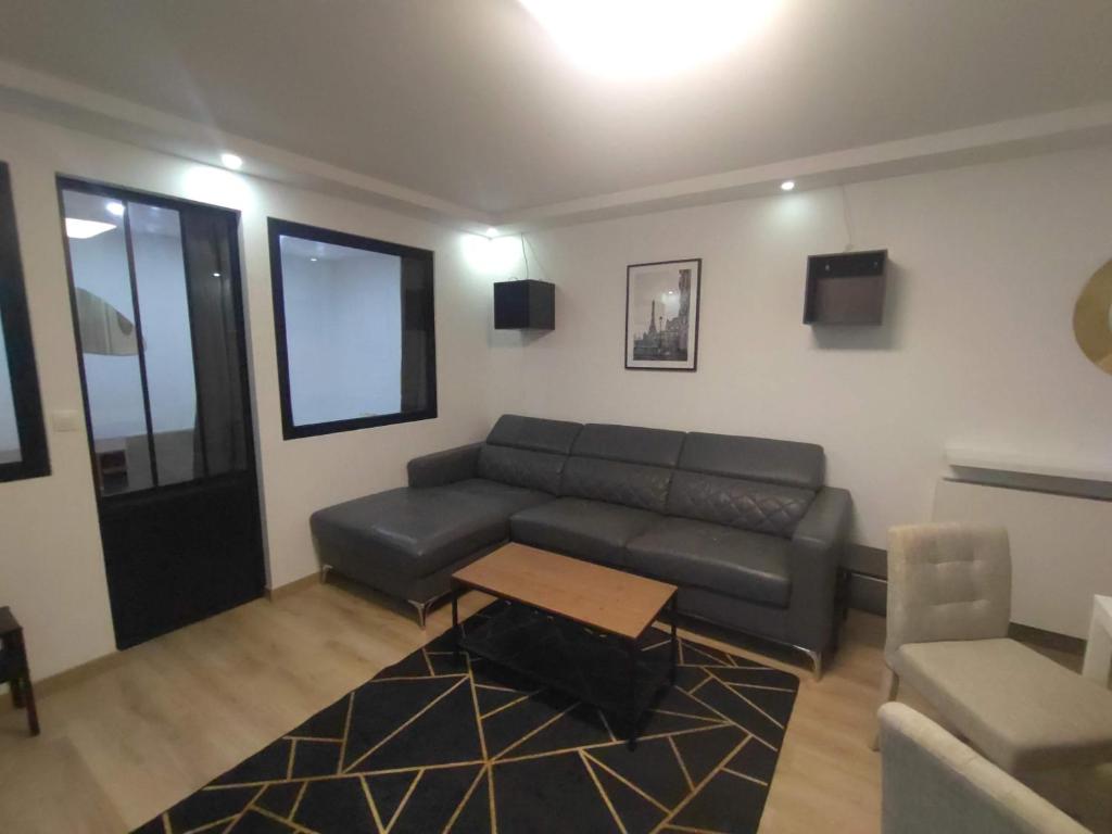 un salon avec un canapé et une table dans l'établissement 4 min walk to metro, 3 bedrooms &Salon, La Défense, à Courbevoie
