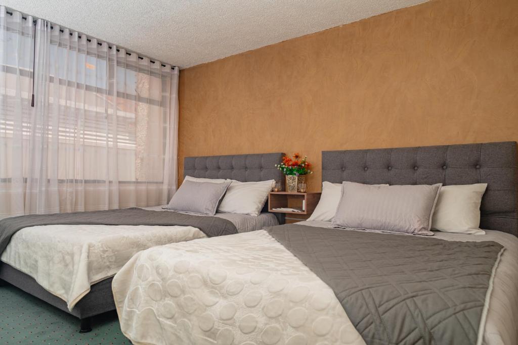 two beds sitting next to each other in a bedroom at Innovar Casa Hostal in Bogotá