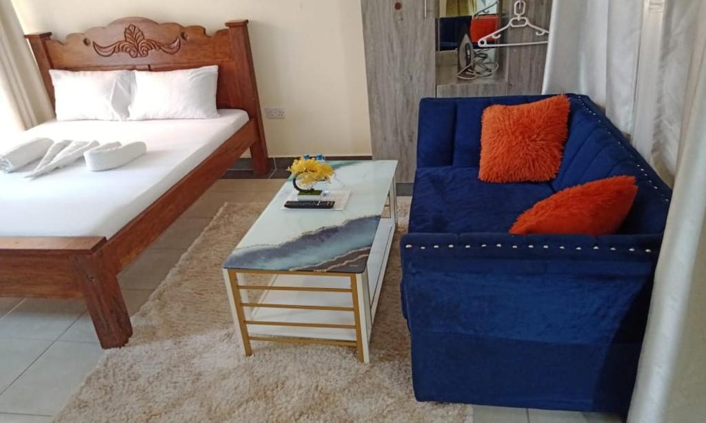 a room with a bed and a chair and a table at MJ homes in Mtwapa