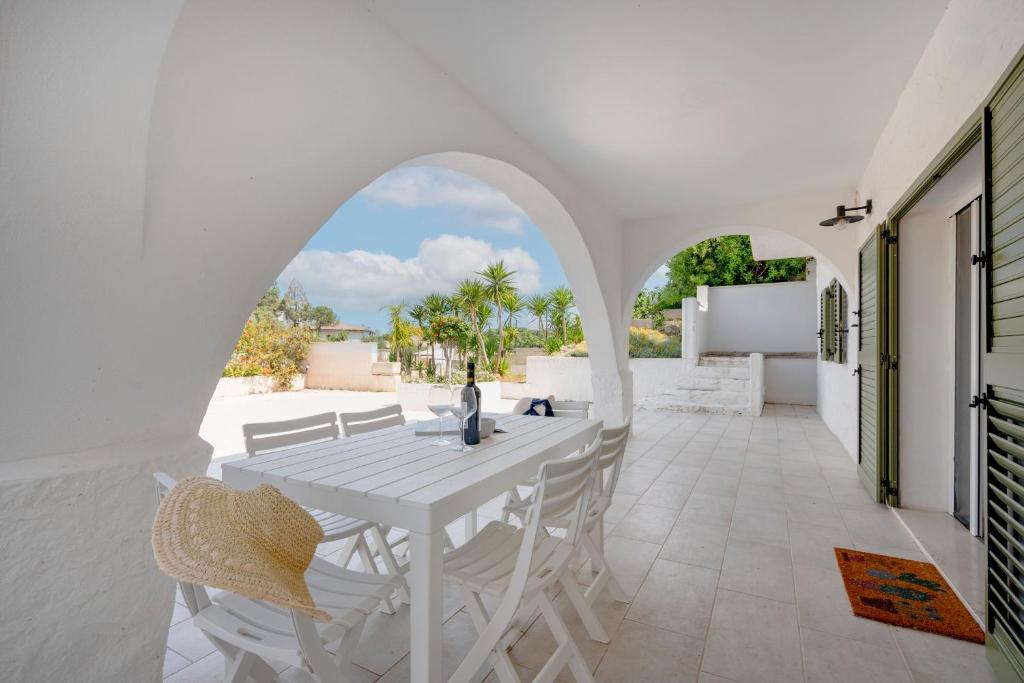 a white table and chairs on a patio at GuestHost - Oasi Monticelli in Polignano a Mare