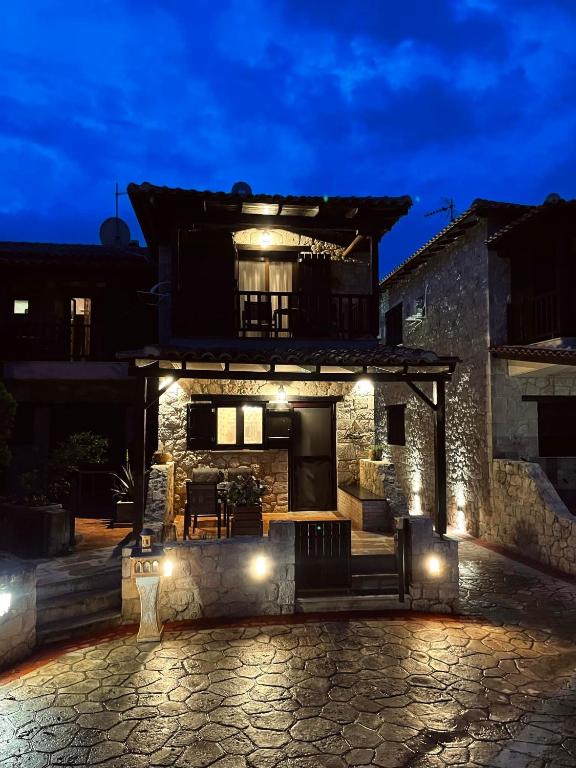a stone house with a patio at night at Your Afytos Home in Afitos