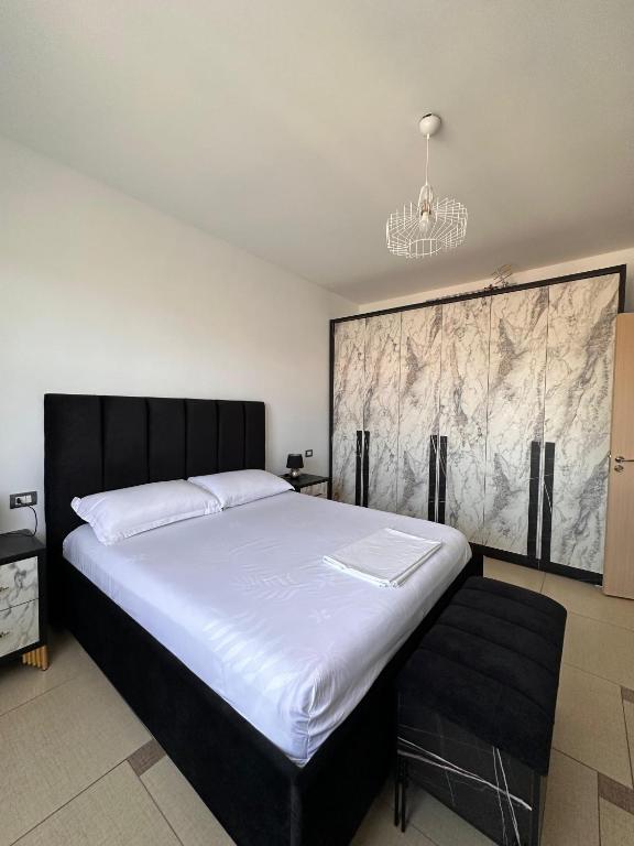 a bedroom with a large bed with white sheets at Xh&S Apartament in Durrës