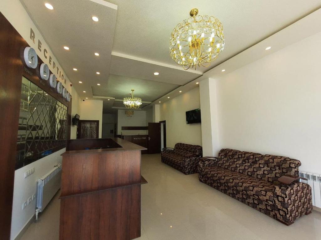 a living room with couches and a chandelier at Отель Диёр Плюс in Samarkand