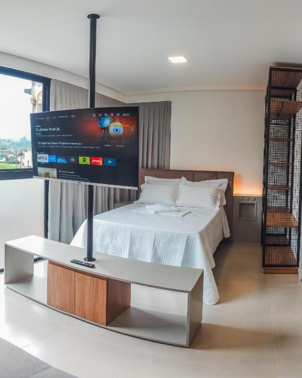 a room with a bed and a flat screen tv at Loft Bamberg 202-Pomerode in Pomerode