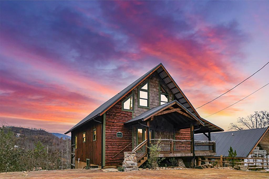une cabane en rondins avec un coucher de soleil en arrière-plan dans l'établissement Aspen Lodge by Venture Smoky Mountains, à Gatlinburg