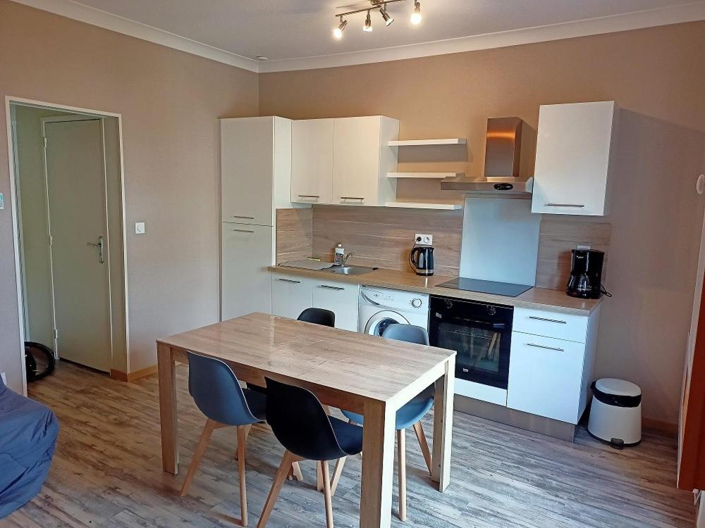 une cuisine avec une table et des chaises dans une pièce dans l'établissement Appartement Saint Malo, à Saint-Malo