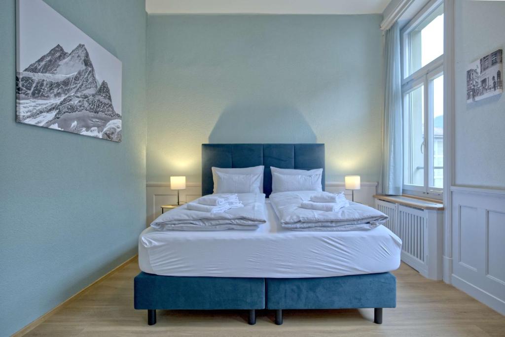 sypialnia z dużym łóżkiem z niebieskim zagłówkiem w obiekcie BANK House Studio M 102 - GRIWA RENT w mieście Interlaken
