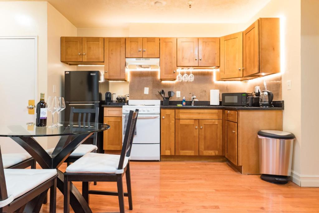 Una cocina con gabinetes de madera y una mesa con sillas. en 1BR in the Heart of Downtown Boston Famous Nightlife Theater District with Bed Full of Promises TD Garden Common Park MBTA, en Boston