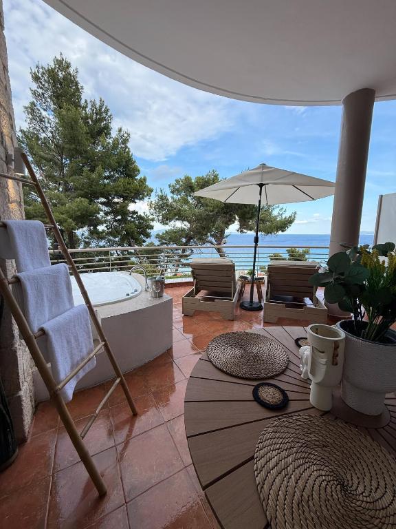 卡利塞亚-豪客迪克斯Amelia Seaview Apartments & Studios的配有浴缸、椅子和遮阳伞的庭院