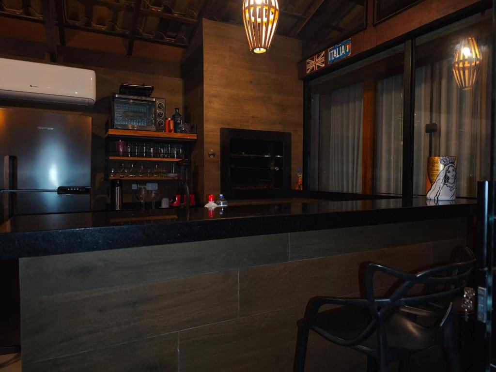 a bar with a counter and chairs in a room at La Playa Bangalô in Arraial d'Ajuda