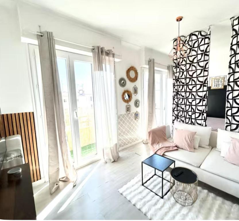 un salon avec un canapé blanc et une table dans l'établissement - appartement-du-centre-ville, à Nice