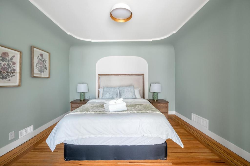 a bedroom with a large white bed with two lamps at Comfort House in Kerrisdale Private and Shared Rooms in Vancouver