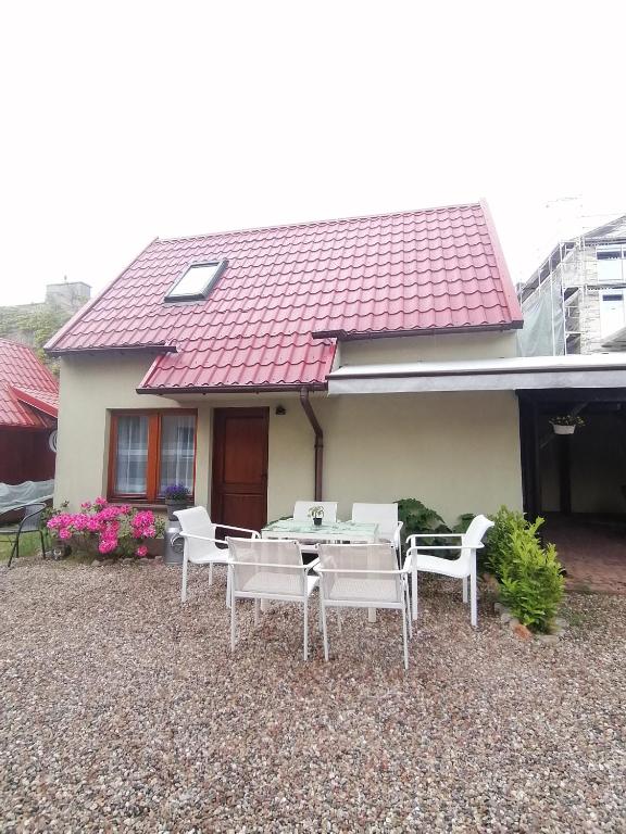 a table and chairs in front of a house at Domek dla rodziny in Jastarnia