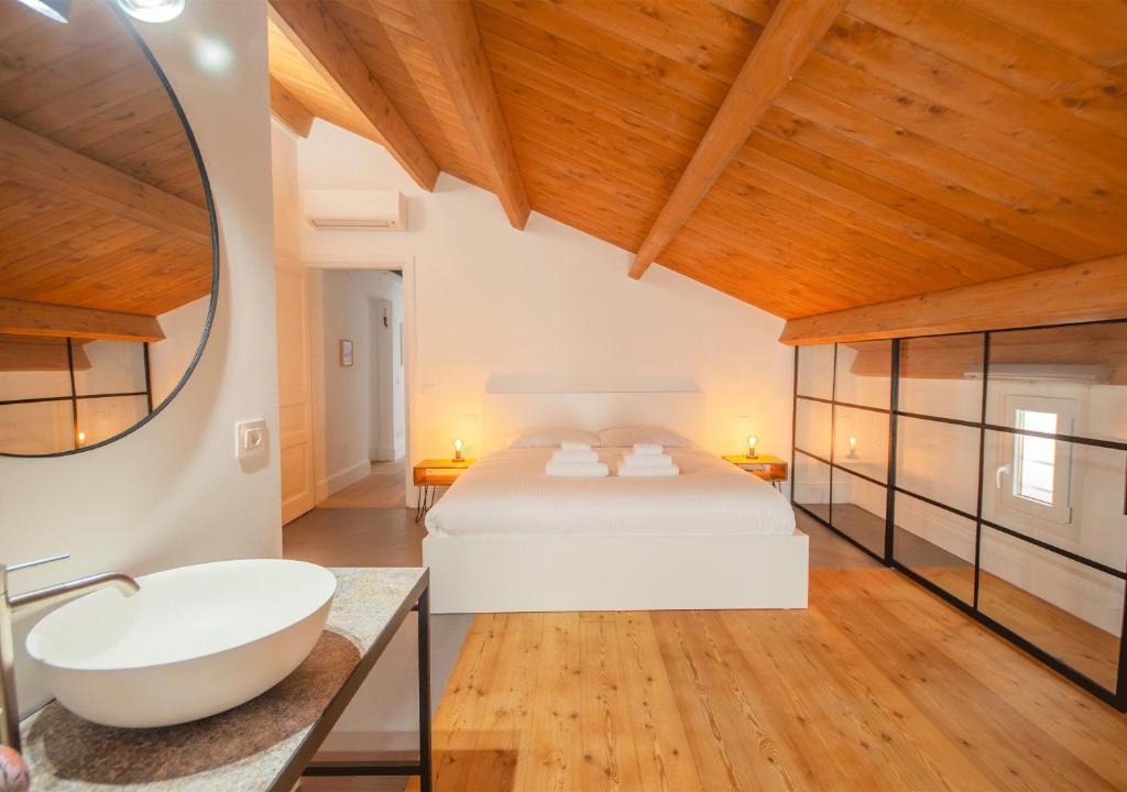 a bedroom with a white bed and a bath tub at Colosseo apartment eleganza e comfort in Rome