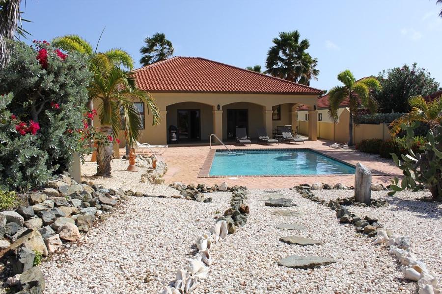 una casa con piscina en un patio en Perfect Sunset View, en Palm-Eagle Beach