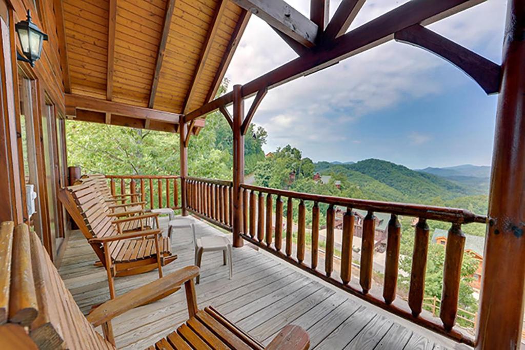 Un porche con dos sillas y vista a las montañas. en Eagles Nest by Venture Smoky Mountains, en Sevierville