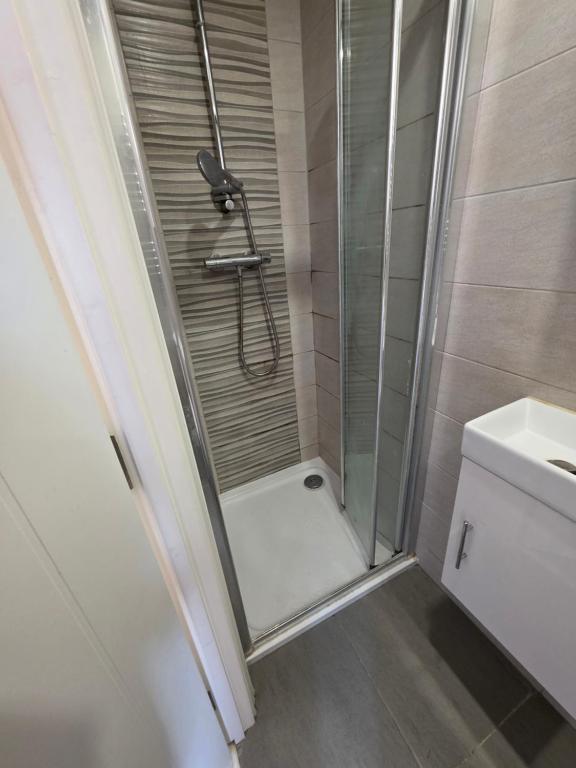 a shower with a glass door in a bathroom at ELY Stay in Ipswich