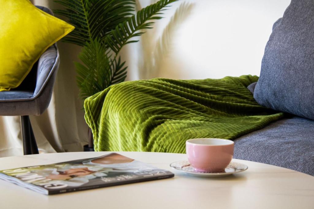 a table with a coffee cup and a magazine on it at Flussblick am Töpferberg 5 in Bad Schwartau