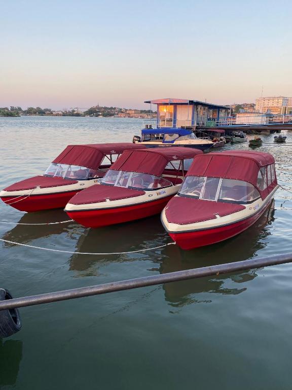 four red boats are parked in the water at Pensiunea Bibanu in Mineri