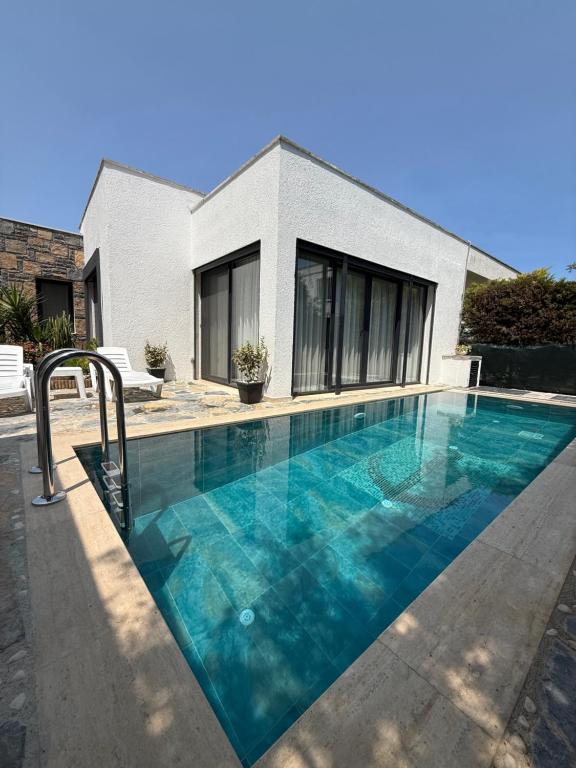 a swimming pool in front of a house at Villa Adventure in Bodrum City