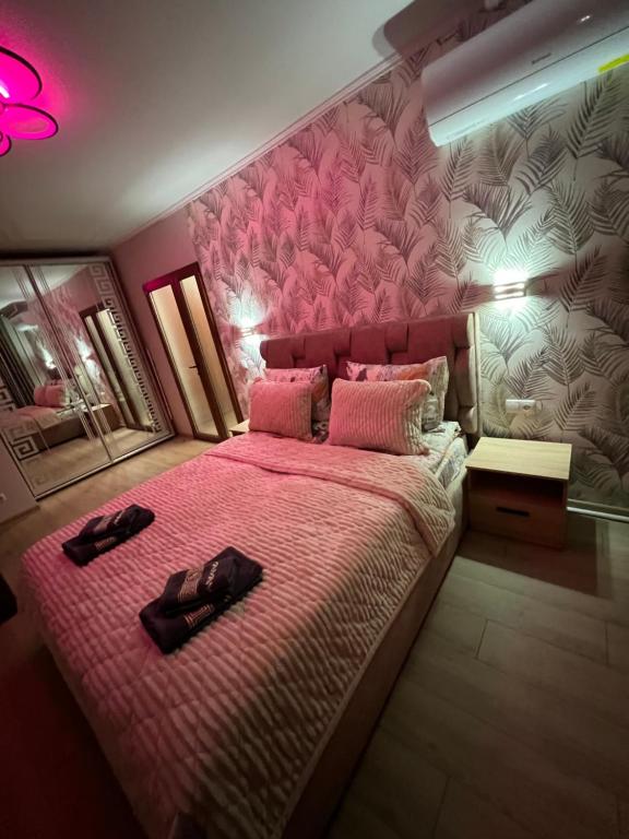 a bedroom with a pink bed with shoes on it at Однокімнатна квартира in Chernivtsi
