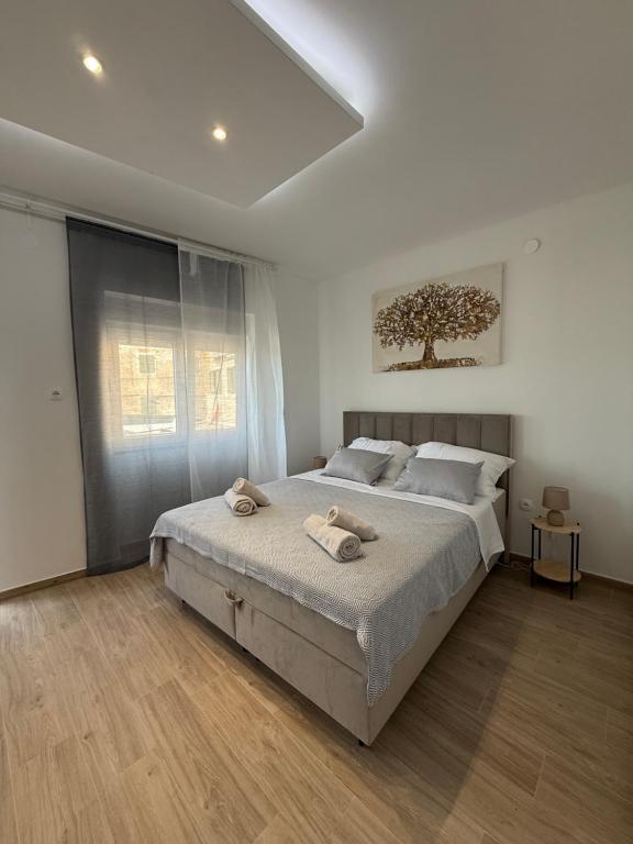 a bedroom with a large bed with two towels on it at Studio apartmani villa Nicol in Pirovac