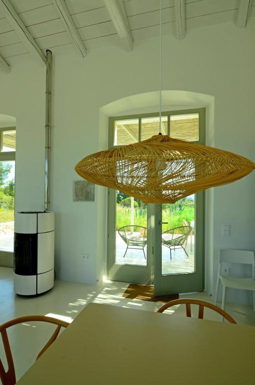 a dining room with a table and a light fixture at Island residence in Logothetiánika