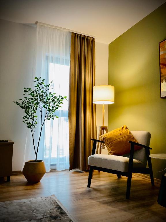 a living room with a chair and a lamp and a plant at The Olive Spot in Cristian