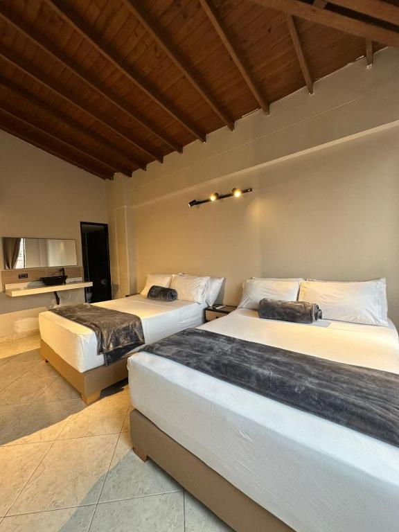 a bedroom with two beds and a television at Hotel Coral Boutique in Medellín