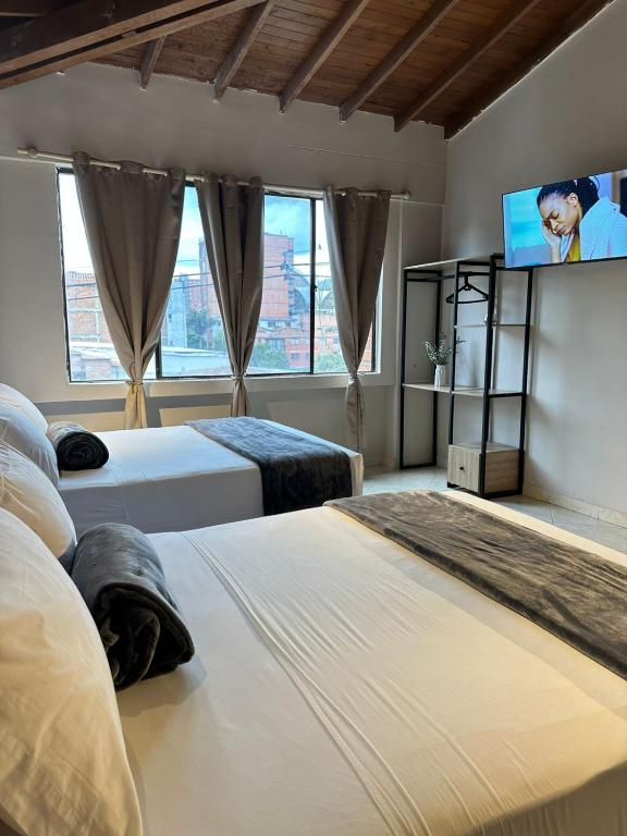 Un dormitorio con dos camas y un televisor de pantalla plana. en Hotel Coral Boutique, en Medellín