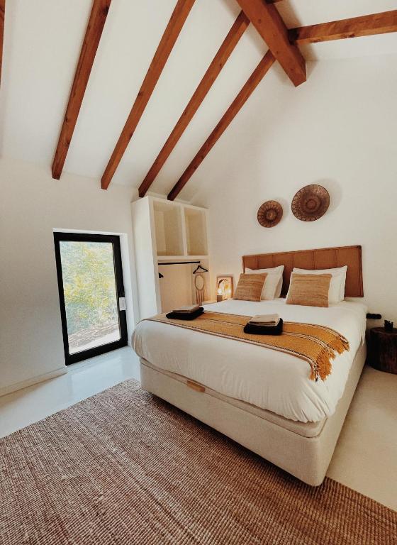 a bedroom with a large bed and a window at Lusterra Grounds in Amarante