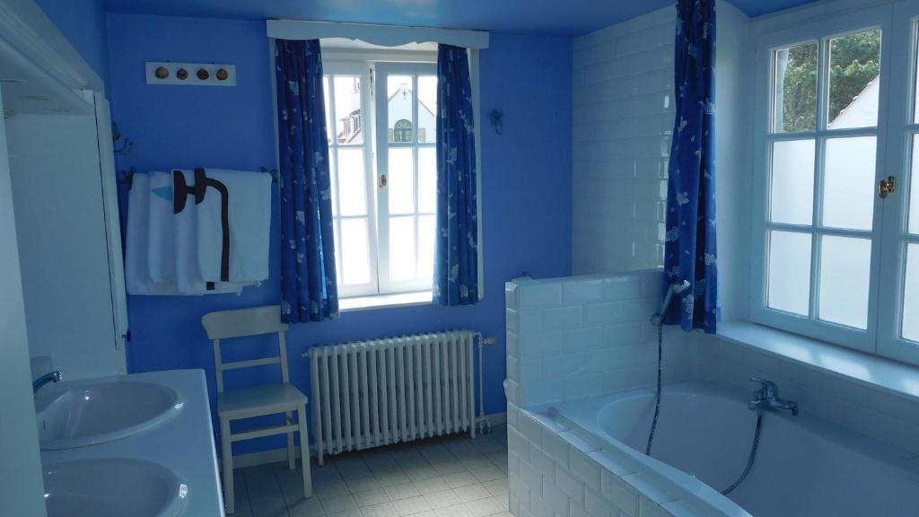 ein blaues Badezimmer mit einer Badewanne und einem Waschbecken in der Unterkunft B&B Dreamcottage in Knokke-Heist