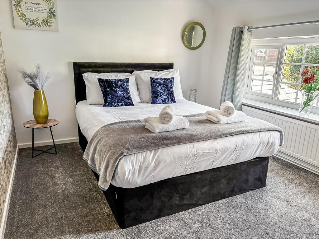 a bedroom with a large bed with towels on it at Yellow House Cottage in Southport