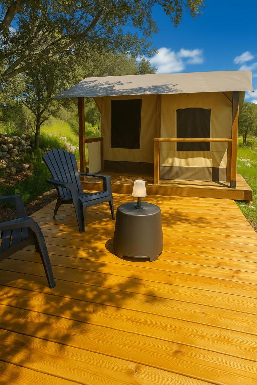 une terrasse avec une tente, deux chaises et une table dans l'établissement La Tente de Mercone - Golu, à Corte