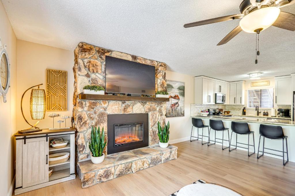 a living room with a fireplace and a kitchen at Lake and Pool Access Lazy Days Condo with Balcony! in Osage Beach