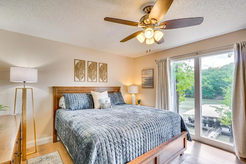 a bedroom with a bed with a ceiling fan and a window at Lake and Pool Access Lazy Days Condo with Balcony! in Osage Beach