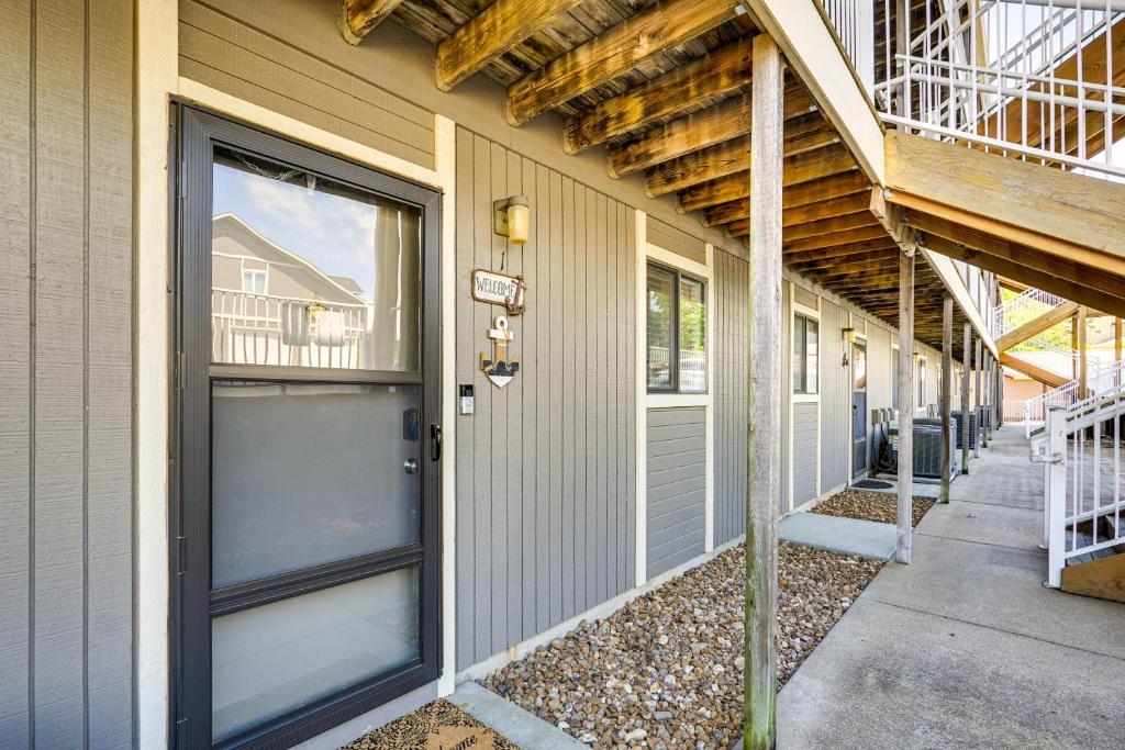 a building with two garage doors and a balcony at Lake and Pool Access Lazy Days Condo with Balcony! in Osage Beach