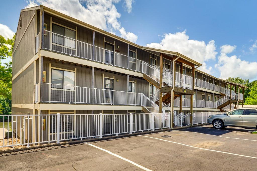 a building with balconies and a car parked in a parking lot at Lake and Pool Access Lazy Days Condo with Balcony! in Osage Beach